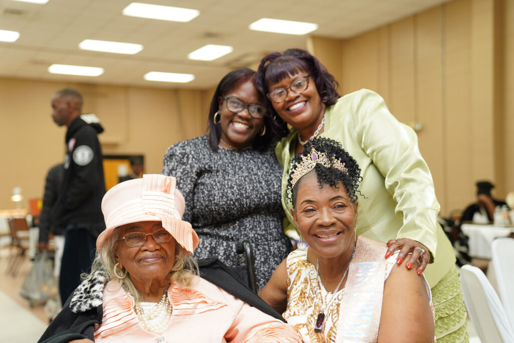 Four women pose for a photo at a birthday celebration