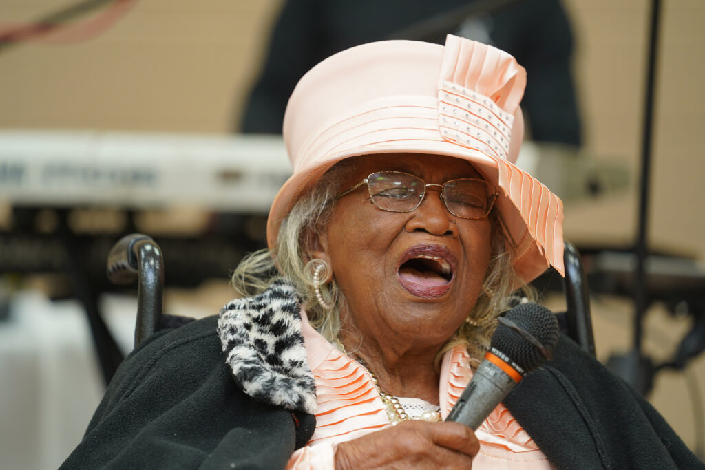 Elder lady sings with mic in her hand