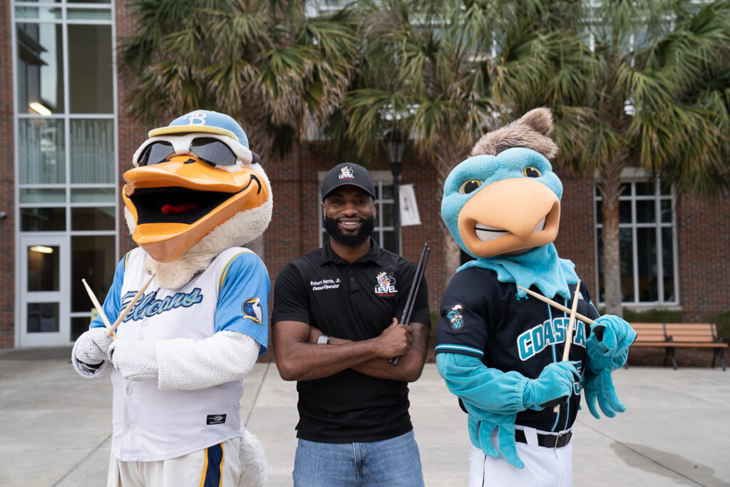 Chauncey the Chanticleer and Splash with the Myrtle Beach Pelicans with drumsticks at the Rimedy HBCU Drumline Showcase.